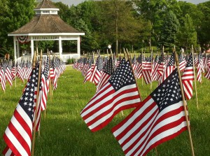 US flags in open field with gazebo