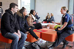 Students listening to an officer in a library