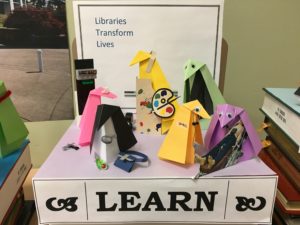 origami penguins representing a variety of instruction departments near a sign reading "Learn."