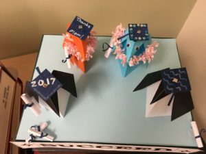 origami penguins in graduation caps that are decorated with "2017" and "Thanks Mom!" and bedazzled with jewels.