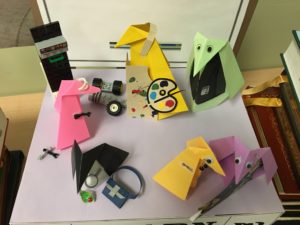 origami penguins in art smocks, working on robots and wearing business attire