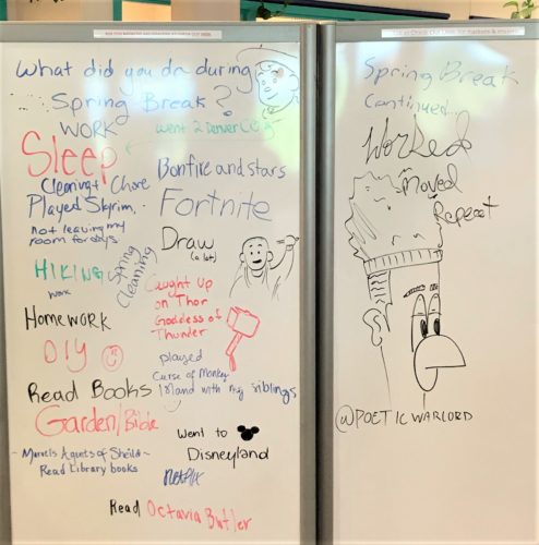 White board in question reads: What did you do during Spring Break? Handwritten answers include: sleep, work, bonfire and stars, draw, hiking, read books, played curse of monkey, moved, played skyrim, cleaning and chores.