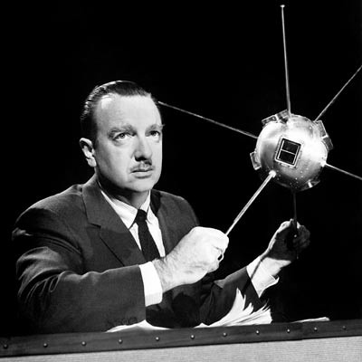 Walter Cronkite with a model of a satellite
