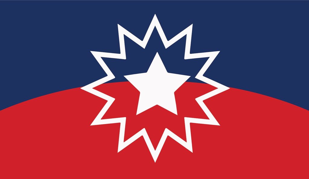 White star outlined with another white starburst with a background of red at the top and bright navy blue at the base: The Juneteenth flag