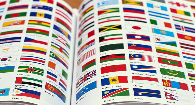 encyclopedia lays open to page with flags from countries around the world