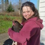 Tammy holding a dark brown chicken