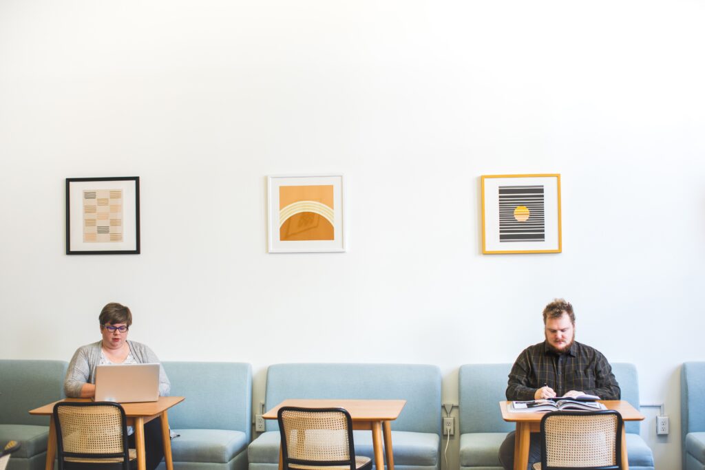 Big and tall man and plus-size woman at work in bright, open office workplace