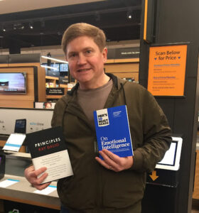 a man holding two books.