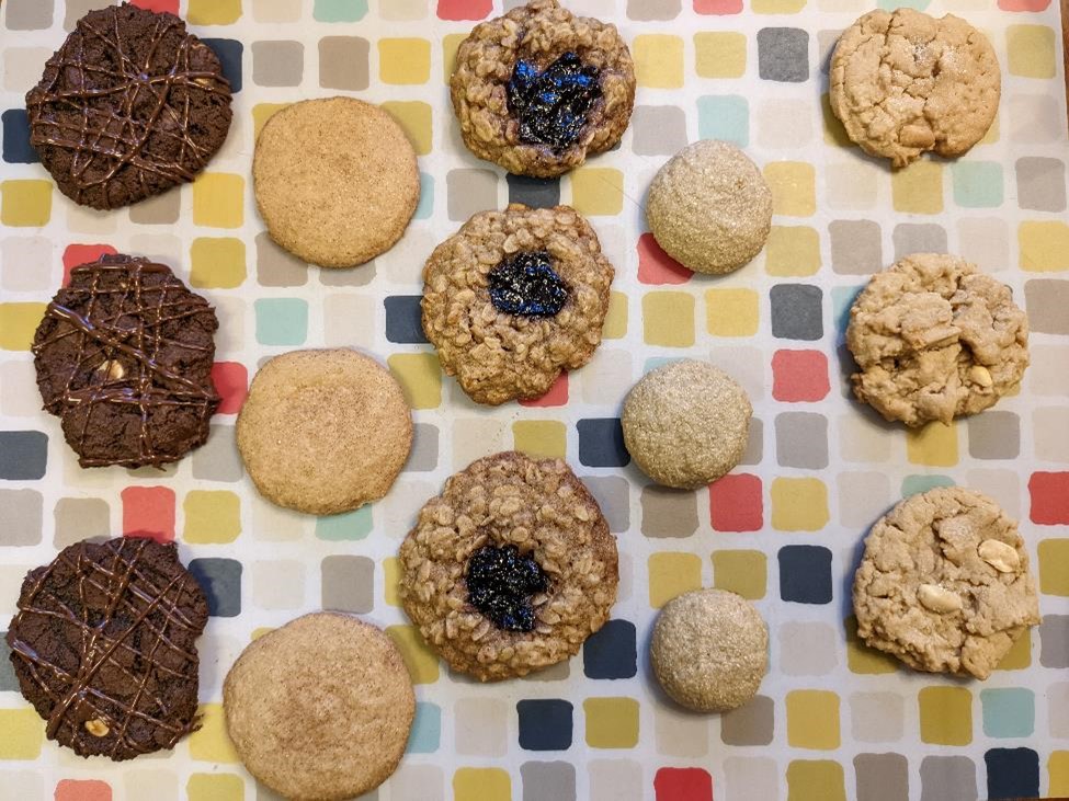 Chocolate, cinnamon, oatmeal, sunflower, and peanut butter cookies on a colorful placemat