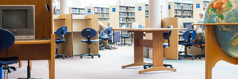 Library shelves, tables, globe, and television