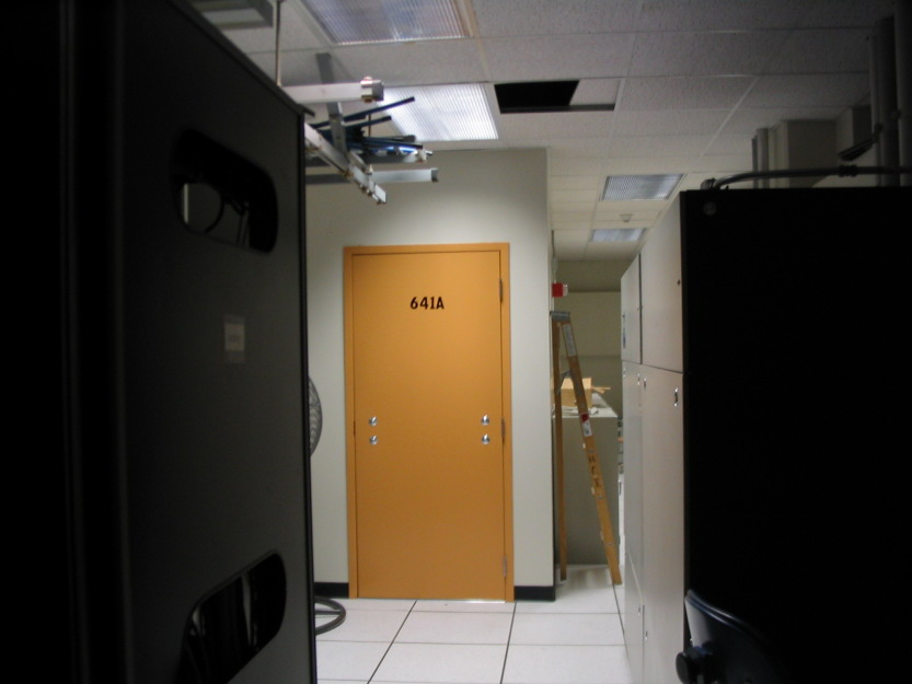 Photograph of door without a doorknob in an artificially lit room.